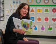 woman reads book to children 
